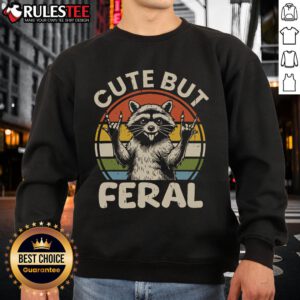 Vintage retro sweatshirt featuring a cute but feral raccoon design against a sunset backdrop.