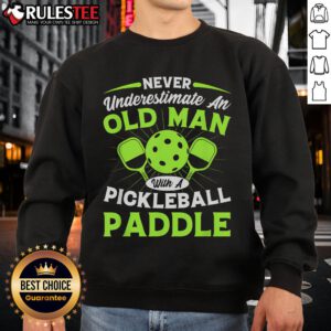 Old man wearing an 'Awesome Never Underestimate An Old Man With A Pickleball Paddle' sweatshirt, ready for pickleball.