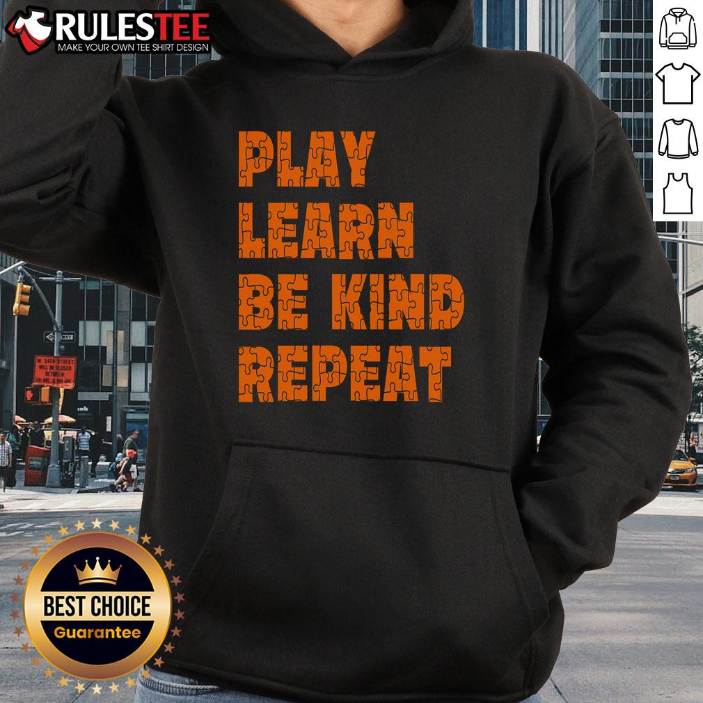 Child wearing an orange hoodie with 'Play, Learn, Be Kind, Repeat' for Autism Awareness Unity Day.