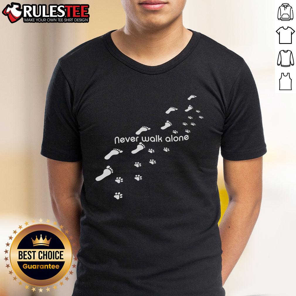 Alt Text: Cute dog owner wearing 'Never Walk Alone' T-shirt with dog paw print, celebrating their love for pets.