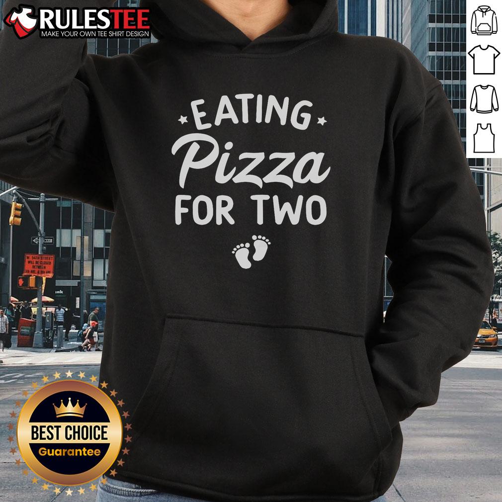 Cute couple in matching hoodies eating pizza, celebrating funny pregnancy announcement with joy and laughter.