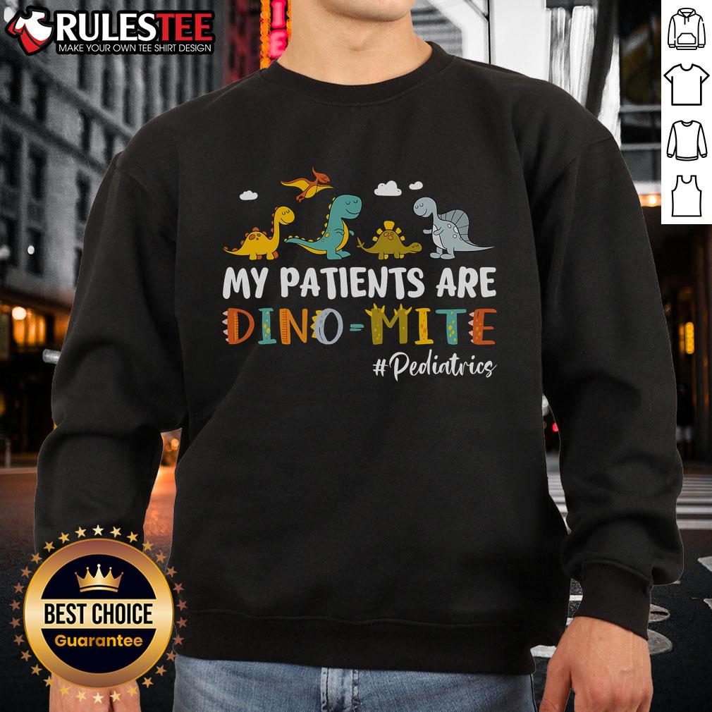 Pediatric nurse wearing a 'My Patients Are Dino-Mite' dinosaur sweatshirt, showcasing fun and playful healthcare vibe.