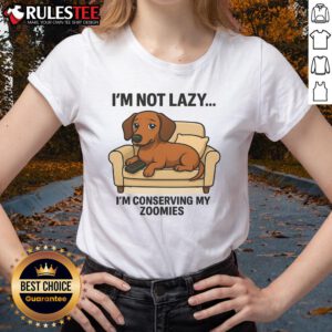 Funny dog lounging with a playful expression, wearing a I'm not lazy, I'm conserving my zoomies tee. Perfect for pet lovers!