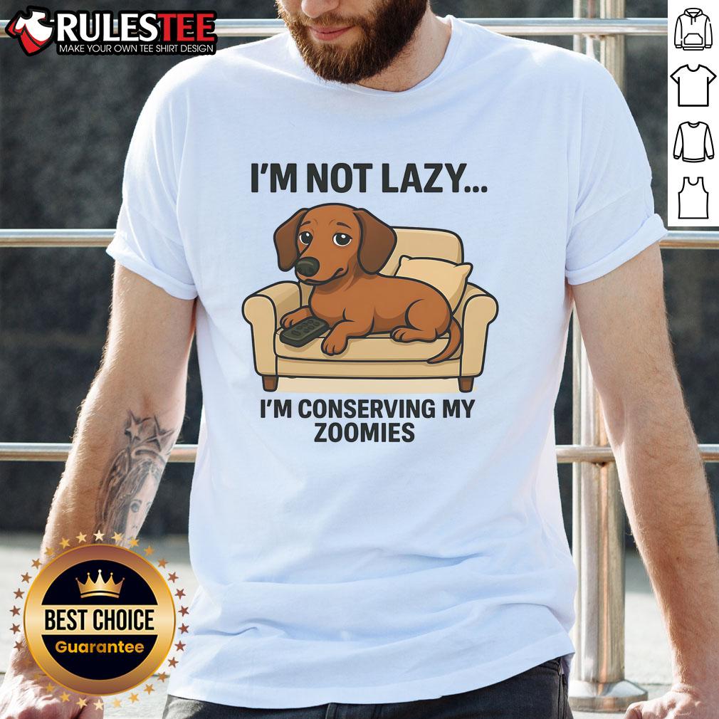 Alt Text: Funny dog wearing 'I'M Not Lazy I'M Conserving My Zoomies' T-shirt, showcasing a playful pet attitude and humor.