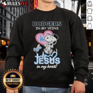 Cozy Snoopy Peanuts sweatshirt featuring 'Los Angeles Dodgers in my veins, Jesus in my heart' design.