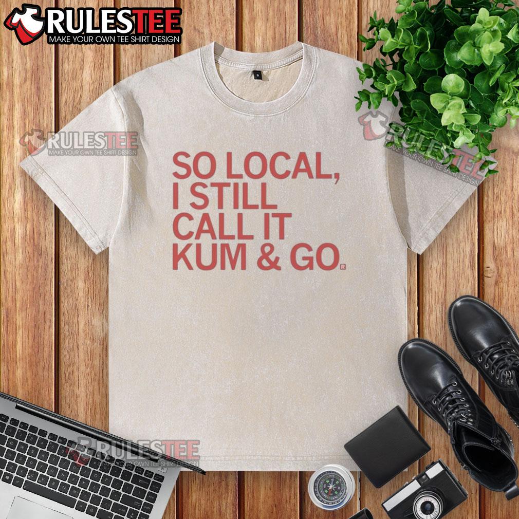 Good-So-Local-I-Still-Call-It-Kum-And-Go washed t-shirt displayed on a wooden surface with a casual styling.