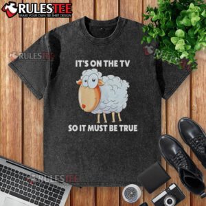 Funny sheep graphic on 'It's on the TV, so it must be true' washed t-shirt, perfect for humor and casual wear.