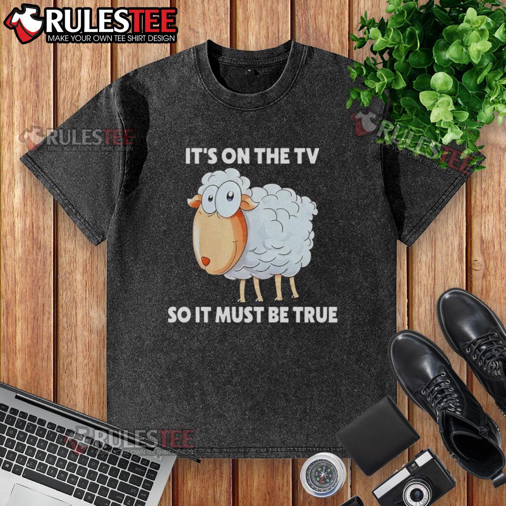 Funny sheep graphic on 'It's on the TV, so it must be true' washed t-shirt, perfect for humor and casual wear.
