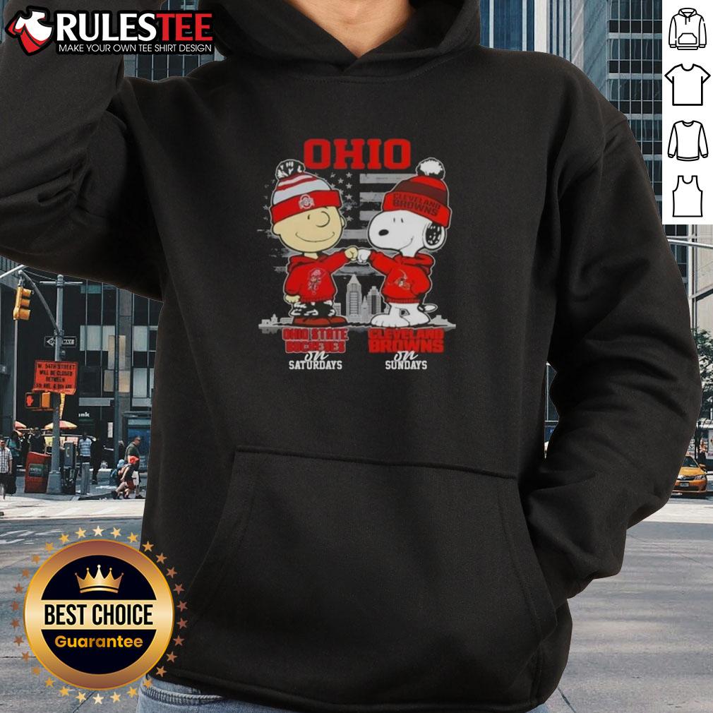 Happy Charlie Brown in Ohio State Buckeyes hoodie next to Snoopy in Cleveland Browns attire against a skyline backdrop.