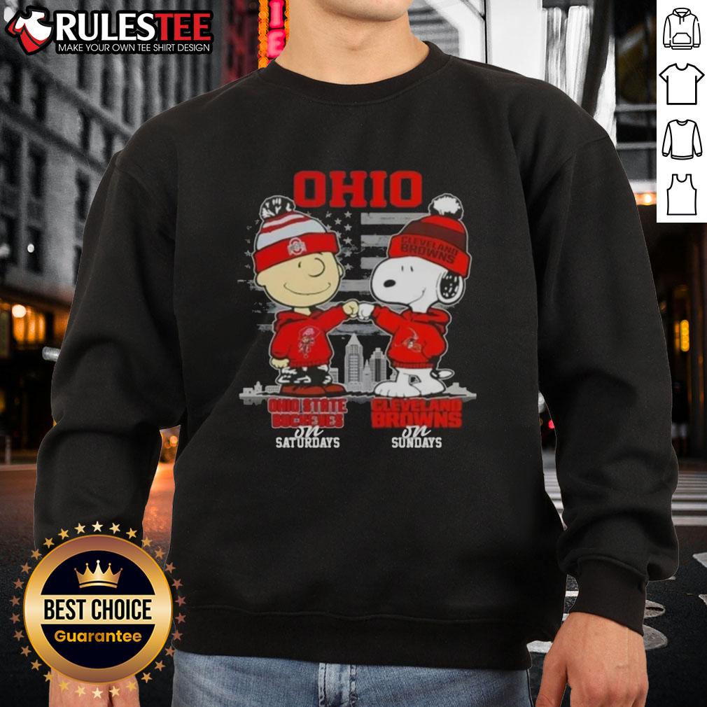 Alt Text: Happy Charlie Brown in Ohio State Buckeyes sweatshirt and Snoopy in Cleveland Browns sweatshirt against skyline.